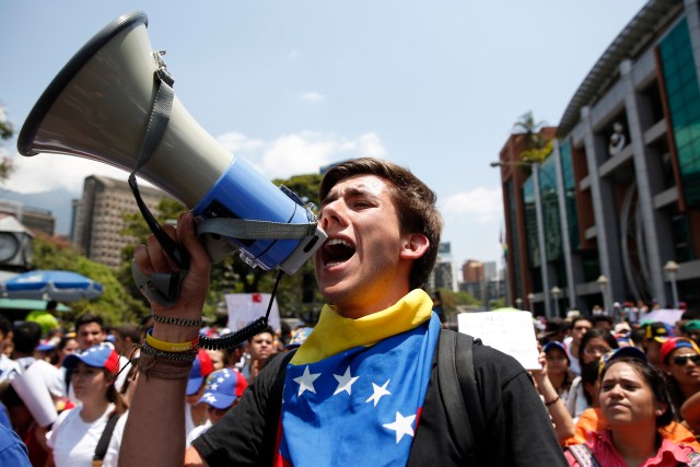 An anti-government protester shouts into a loudhailer during a demonstration in Caracas