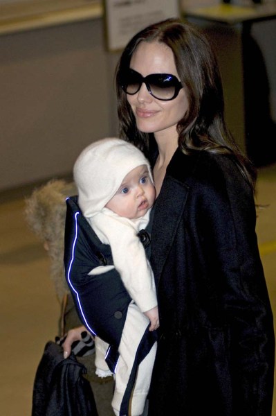 La actriz estadounidense Angelina Jolie sostiene a su hija Vivienne a su llegada al aeropuerto internacional de Narita, en Tokio