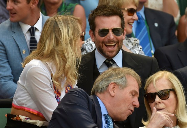 Actor Bradley Cooper and model Suki Waterhouse sit on Centre Court at the Wimbledon Tennis Championships, in London