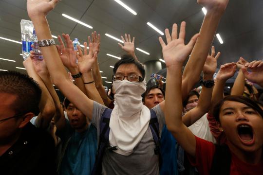 En la imagen, manifestantes entonan consignas frente a la policía durante una confrontación tras una protesta en Hong Kong.