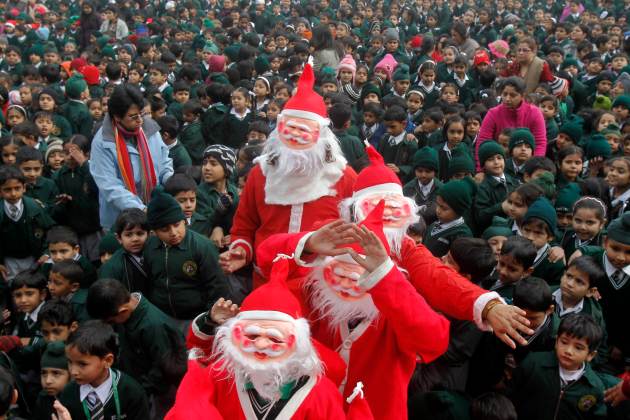 Foto: Estudiantes vestidos como Santa Claus distribuyen dulces entre los niños durante una celebración de la Navidad en una escuela en la norteña ciudad india de Chandigarh. REUTERS / Ajay Verma