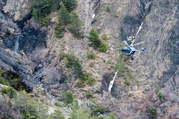 A photo released March 25, 2015 by the French Interior Ministry shows a French gendarme helicopter flying over the crash site of an Airbus A320, near Seyne-les-Alpes