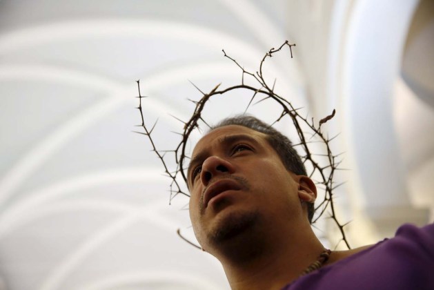 Venezuelan penitent wearing a wreath of thorns attends a mass at the Santa Teresa's Basilica during Holy Week celebrations in Caracas