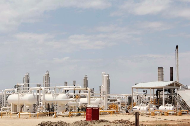 Una planta de procesamiento de petróleo y gas alimentado por pozos de esquisto locales se representa a lo largo de una carretera en las afueras de Carrizo Springs, cerca de 30 millas (48 km) de la frontera con México (David Alire / Reuters)