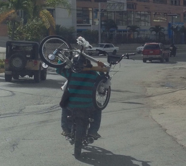 Así llevan una bicicleta en una moto (fotos)