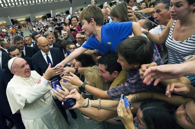 Fotografía facilitada por el Osservatore Romano que muestra al papa Francisco (i) saludando a los fieles durante la audiencia semanal en el salón Pablo VI en la ciudad del Vaticano, Vaticano hoy 5 de agosto de 2015. El papa Francisco aseguró que hay que mostrar más compasión para las situaciones familiares irregulares, como los divorcios en parejas católicas. EFE