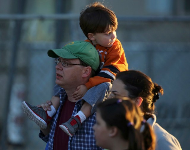 A young boy is carried as people gather ahead of a papal parade featuring Pope Francis in Washington September 23, 2015. Pope Francis, who is on his first visit to the United States, will meet with U.S. President Barack Obama, followed by a parade through the streets of Washington later in the morning. REUTERS/Gary Cameron