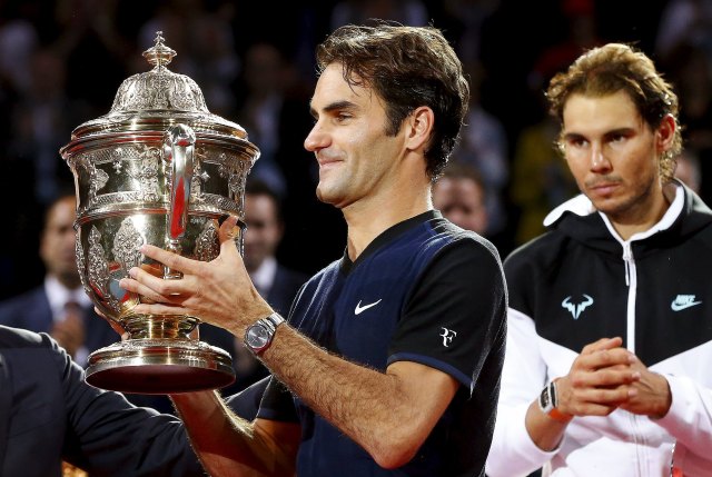 Switzerland's Roger Federer (L) holds the trophy after winning his match against Rafael Nadal of Spain (R) at the Swiss Indoors ATP men's tennis tournament in Basel, Switzerland, November 1, 2015. REUTERS/Arnd Wiegmann
