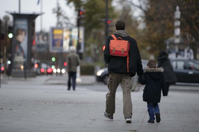 A child holds a relative's hand on his way to school early on November 16, 2015 in Paris, three days after the terrorist attacks that left over 130 dead and more than 350 injured. Reassure , explain, hold a minute of silence, schools are mobilized to welcome pupils and students, sometimes shocked or confused by the mass of information or rumors related to the attacks. France prepared to fall silent at noon on November 16 to mourn victims of the Paris attacks after its warplanes pounded the Syrian stronghold of Islamic State, the jihadist group that has claimed responsibility for the slaughter.  AFP PHOTO / KENZO TRIBOUILLARD