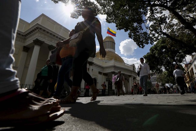People walk past the National Assembly building during a session in Caracas December 10, 2015. REUTERS/Carlos Garcia Rawlins
