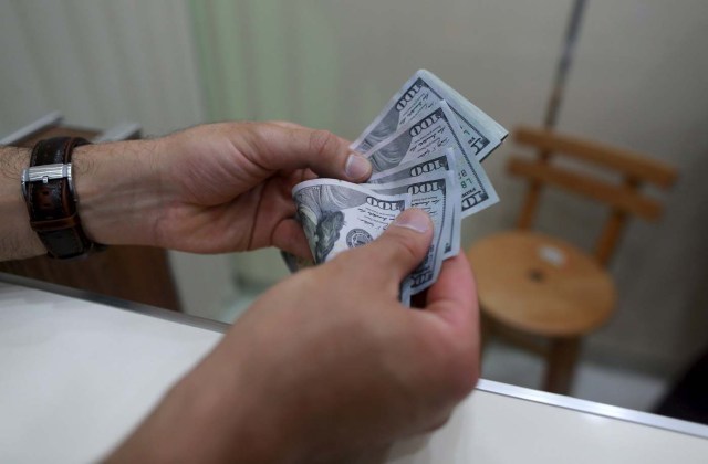 A man buys U.S. dollars in a currency exchange in Benghazi, Libya December 29, 2015. REUTERS/Esam Omran Al-Fetori