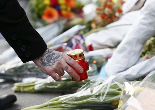 A person places a candle next to tributes left next to a mural of David Bowie in Brixton, south London, January 11, 2016. David Bowie, a music legend who used daringly androgynous displays of sexuality and glittering costumes to frame legendary rock hits "Ziggy Stardust" and "Space Oddity", has died of cancer.  REUTERS/Stefan Wermuth