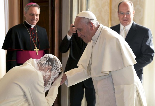 Princess Charlene (L) kisses the hand of Pope Francis next to her husband Prince Albert II of Monaco during a private audience at the Vatican, January 18, 2016. REUTERS/Filippo Monteforte/Pool