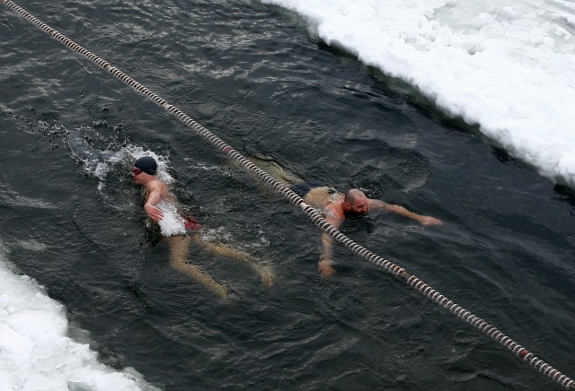 Hombres nadar en aguas heladas de un lago durante las celebraciones de la Epifanía ortodoxa en Minsk, 19 de enero de 2016. Los creyentes ortodoxos marcan la Epifanía, el 19 de enero por sumergirse en aguas heladas, independientemente de las condiciones meteorológicas. REUTERS / Vasily Fedosenko