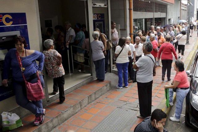People line up to receive their pensions outside a bank branch in Caracas, January 20, 2016. REUTERS/Marco Bello