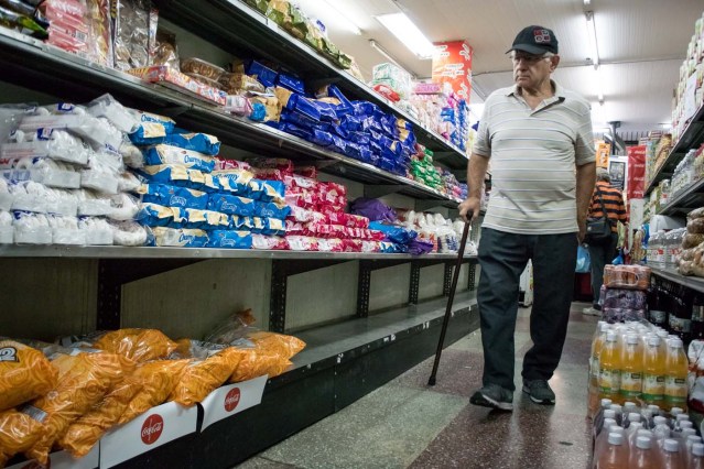 CAR16. CARACAS (VENEZUELA), 11/02/2016.- Un hombre compra en un supermercado hoy, jueves 11 de febrero de 2016, en Caracas (Venezuela). El Parlamento venezolano declaró hoy la "crisis alimentaria nacional" y en virtud de ello pidió que la FAO y la Unicef envíen expertos que evalúen los riesgos que entraña el problema para los 30 millones de habitantes del país caribeño. EFE/Miguel Gutiérrez