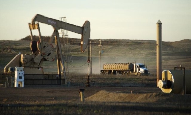 En la imagen, un camión pasa cerca a un pozo petrolero en Dakota del Norte, 1 de noviembre, 2014. Un acuerdo entre algunos productores de la OPEP y Rusia para congelar su producción de crudo quizás "carece de sentido" debido a que Arabia Saudita es el único país con la capacidad de aumentar su bombeo, dijo el miércoles un ejecutivo de alto rango de la Agencia Internacional de Energía (AIE). REUTERS/Andrew Cullen
