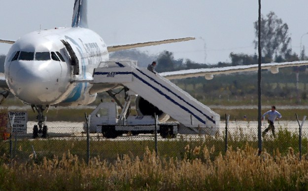 Unidentified people run off the hijacked Egyptair Airbus A320 at Larnaca Airport in Larnaca, Cyprus, March 29, 2016 REUTERS/Yiannis Kourtoglou