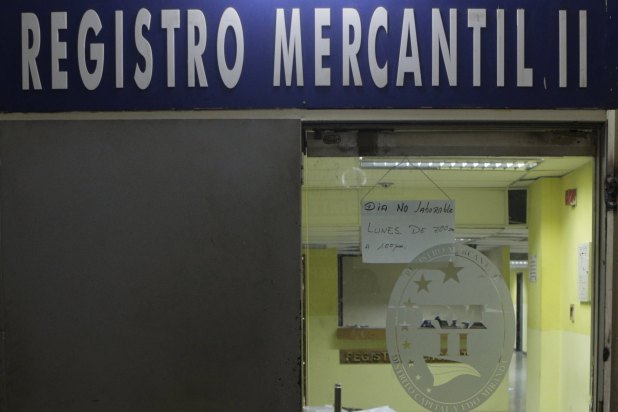 A sign that reads "Non-working day. Monday from 7:00am to 1:00pm", hangs at the door of a closed mercantile registry office in Caracas, April 8, 2016. REUTERS/Marco Bello