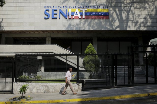 A man walks in front of  a closed national tax authority SENIAT office in Caracas, April 8, 2016. REUTERS/Marco Bello