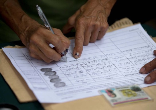 Una persona firma una petición, organizada por la oposición, para iniciar un referendo revocatorio del mandato del presidente de Venezuela Nicolás Maduro en San Cristóbal, el miércoles 27 de abril de 2016. (Foto AP / Fernando Llano)