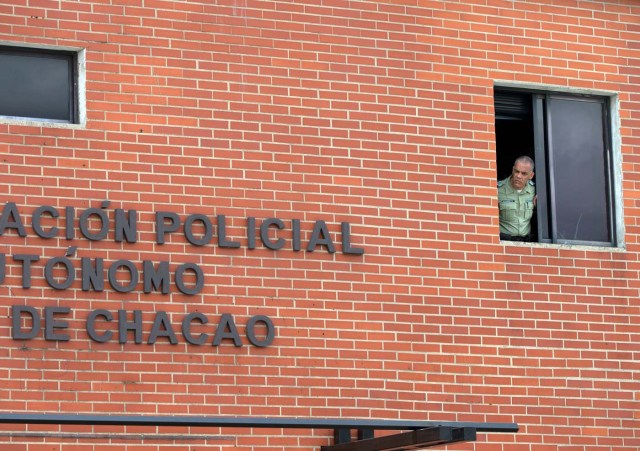 Un agente se asoma desde una ventana en la sede policial de la municipalidad del Chacao en Caracas, Venezuela, el lunes 30 de mayo de 2016. Las autoridades venezolanas dijeron que arrestaron a cuatro hombres por el homicidio del mayor general retirado Félix Velásquez, que fungió como jefe de seguridad del fallecido presidente Hugo Chávez. La procuraduría nacional dijo el lunes que dos de los sospechosos son policías del distrito Chacao de la capital, el cual es gobernado por la oposición. (AP foto/Fernando Llano)