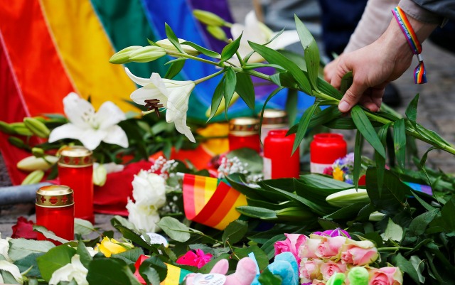 Un hombre coloca las flores para las víctimas del tiroteo en un club nocturno gay en Orlando, en frente de la Embajada de EE.UU. en Berlín, Alemania, 13 de junio de 2016. REUTERS / Hannibal Hanschke