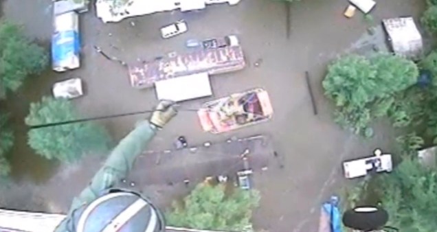 An aircrew from Coast Guard Air Station New Orleans rescues three people from a rooftop due to flooding in Baton Rouge, Louisiana, U.S., in this still image from video taken on August 13, 2016. Coast Guard Air Station New Orleans/Handout via REUTERS ATTENTION EDITORS - THIS IMAGE WAS PROVIDED BY A THIRD PARTY. EDITORIAL USE ONLY