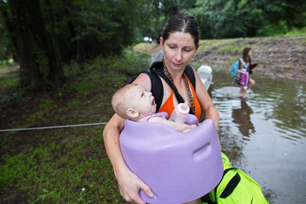 Danielle Blount carga a su niña Ember de tres meses hasta un camión de la Guardia Nacional el domingo 14 de agosto de 2016 cerca de la localidad de Walker, Louisiana, después de que fuertes inundaciones por las intensas lluvias azotaran la región. (AP Foto/Max Becherer)
