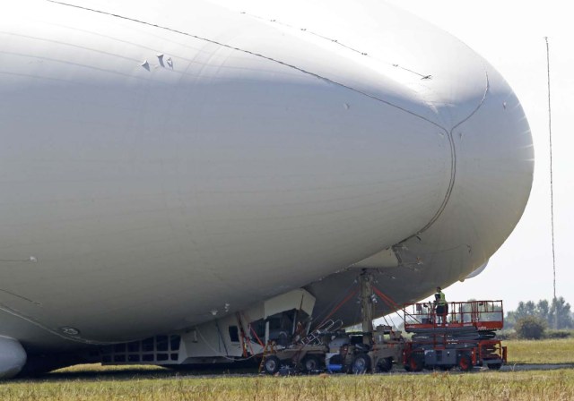 Workers look at damage to the Airlander 10 hybrid airship after a test flight at Cardington Airfield in Britain, August 24, 2016. REUTERS/Darren Staples