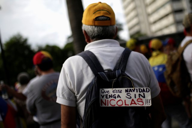 A sign that reads "That this Christmas will come without Nicolas" is seen in the backpack of an opposition supporter during a rally to demand a referendum to remove Venezuela's President Nicolas Maduro in Caracas, Venezuela September 1, 2016. REUTERS/Marco Bello