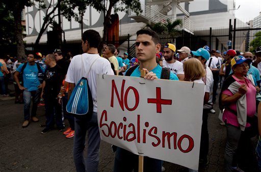 Un hombre sostiene un cartel que reza "No más socialismo" mientras los manifestantes se reúnen para una marcha por Caracas convocada por la oposición, el jueves 1 de septiembre de 2016. (AP Foto/Fernando Llano)