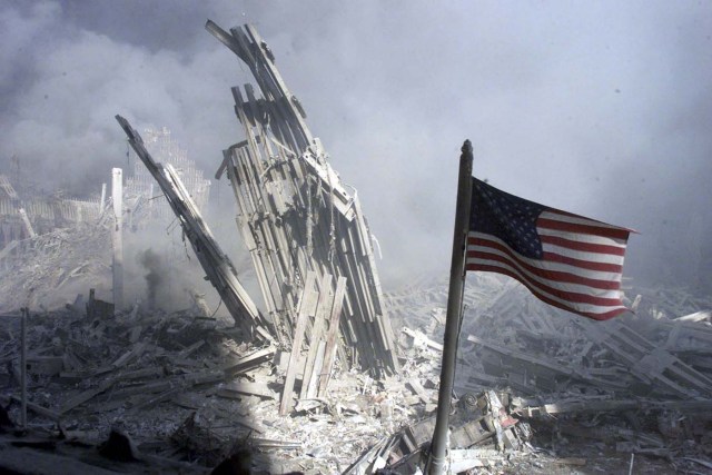 An American flag flies near the base of the destroyed World Trade Center after planes crashed into each of the two towers, causing them to collapse in New York, U.S. on September 11, 2001. REUTERS/Peter Morgan/File Photo