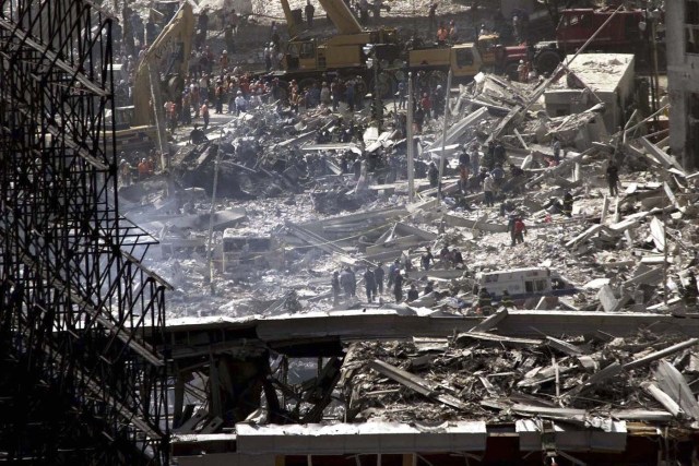 Hundreds of rescuers and emergency workers swarm all over the wreckage of the World Trade Center Towers as they search for trapped survivors of the terrorist attack on the NewYork landmark in New York, U.S. on September 12, 2001. Two hijacked commercial airliners were deliberately crashed into the twin towers bringing them crashing to the ground September 11. REUTERS/Jim Bourg/File Photo