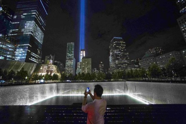 A man takes a photo at the 9/11 Memorial and Museum near the Tribute in Light in Lower Manhattan, New York, September 9, 2015. REUTERS/Andrew Kelly/File Photo
