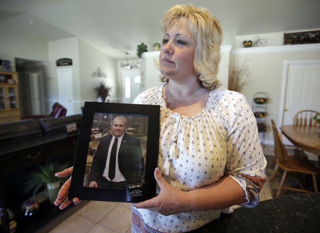 Laurie Holt sostiene una fotografía de su hijo Josh Holt, en su casa en Riverton, Utah. La representante federal Mia Love intercederá por el hombre de Utah que ha estado encarcelado en Venezuela dos meses por cargos relacionados con armas de fuego, y exigirá su liberación. (AP Foto/Rick Bowmer, archivo)