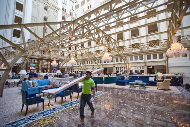Workers continue work at the Trump International Hotel during the 'soft-opening' in downtown Washington, Monday, Sept. 12, 2016 in Washington. The luxury hotel Donald Trump has built in an iconic downtown Washington building is set to open. The Trump International Hotel will begin serving guests Monday. There won't be any fanfare around the opening, which is known as a "soft opening." Grand-opening ceremonies are being planned for October. The Trump Organization won a 60-year lease from the federal government to transform the Old Post Office building on Pennsylvania Avenue into a hotel. (AP Photo/Pablo Martinez Monsivais)