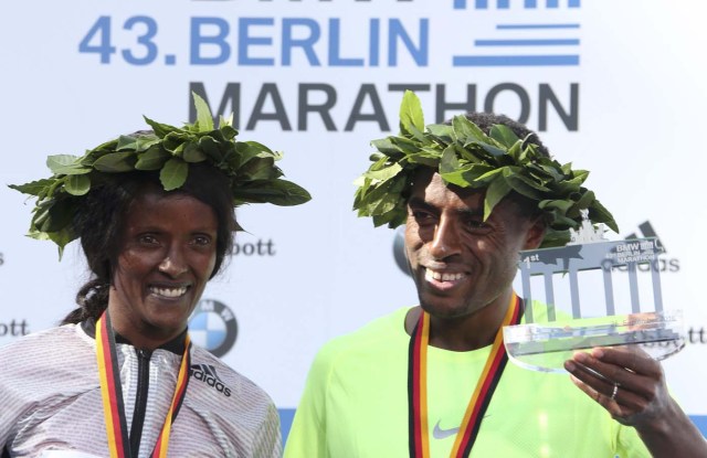 Winners Kenenisa Bekele (R) of Ethiopia and Aberu Kebede of Ethiopia celebrate during the victory ceremony at the Berlin marathon in Berlin, Germany, September 25, 2016. REUTERS/Fabrizio Bensch