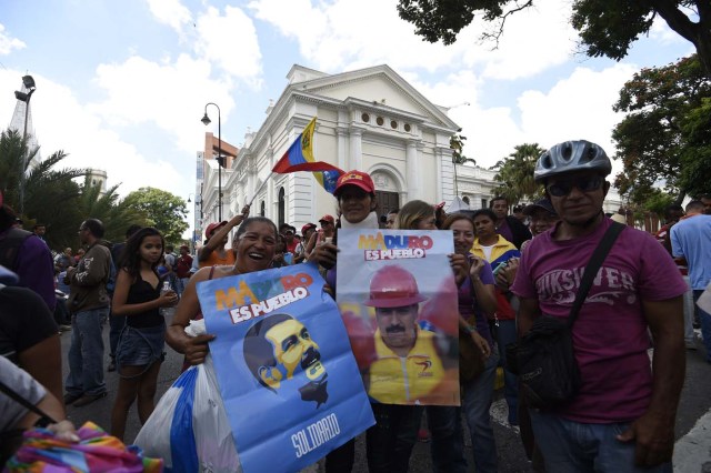 Supporters of Venezuelan President Nicolas Maduro, demonstrate outside the National Assembly during an extraoridinary session called by opposition leaders, in Caracas on October 23, 2016. The opposition Democratic Unity Movement (MUD) called a Parliamentary session to debate putting President Nicolas Maduro on trial to "restore democracy" in an emergency session that descended into chaos as supporters of the leftist leader briefly seized the chamber. / AFP PHOTO / JUAN BARRETO