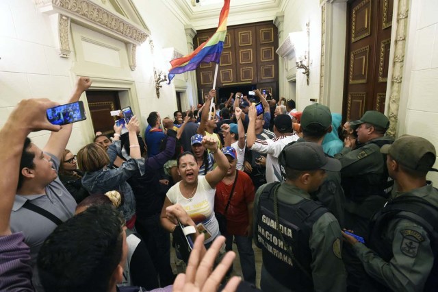 Supporters of Venezuelan President Nicolas Maduro force their way to the National Assembly during an extraoridinary session called by opposition leaders, in Caracas on October 23, 2016. The Democratic Unity Movement(MUD), opposite to Nicolas Maduro's government called a Parliamentary session to discuss restructuring of the Boliviarian Republic of Venezuela's Constitution, the constitutional order and democracy as main issues. Demonstrators outside the building forced their entrance to interrupt the debate and the session was suspended. / AFP PHOTO / JUAN BARRETO