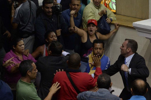 Supporters of Venezuelan President Nicolas Maduro force their way to the National Assembly during an extraoridinary session called by opposition leaders, in Caracas on October 23, 2016. The opposition Democratic Unity Movement (MUD) called a Parliamentary session to debate putting President Nicolas Maduro on trial to "restore democracy" in an emergency session that descended into chaos as supporters of the leftist leader briefly seized the chamber. / AFP PHOTO / FEDERICO PARRA
