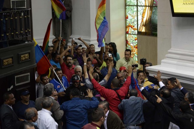 Supporters of Venezuelan President Nicolas Maduro force their way to the National Assembly during an extraoridinary session called by opposition leaders, in Caracas on October 23, 2016. The opposition Democratic Unity Movement (MUD) called a Parliamentary session to debate putting President Nicolas Maduro on trial to "restore democracy" in an emergency session that descended into chaos as supporters of the leftist leader briefly seized the chamber. / AFP PHOTO / FEDERICO PARRA
