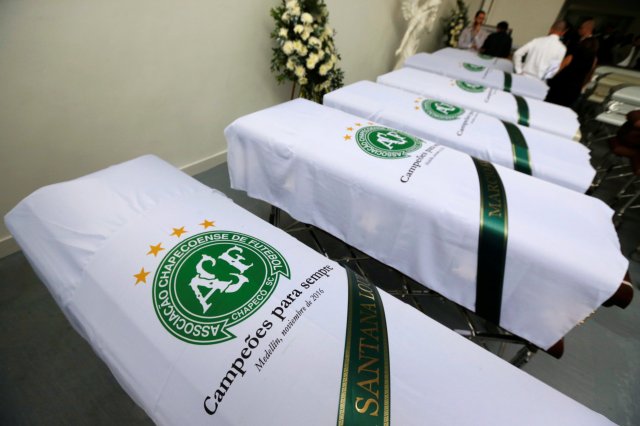 Blankets bearing the crest of Brazilian soccer team Chapecoense are placed on coffins holding the remains of the victims who died in an accident of the plane that crashed into the Colombian jungle with the team's players onboard, in Medellin, Colombia December 1, 2016. REUTERS/Jaime Saldarriaga