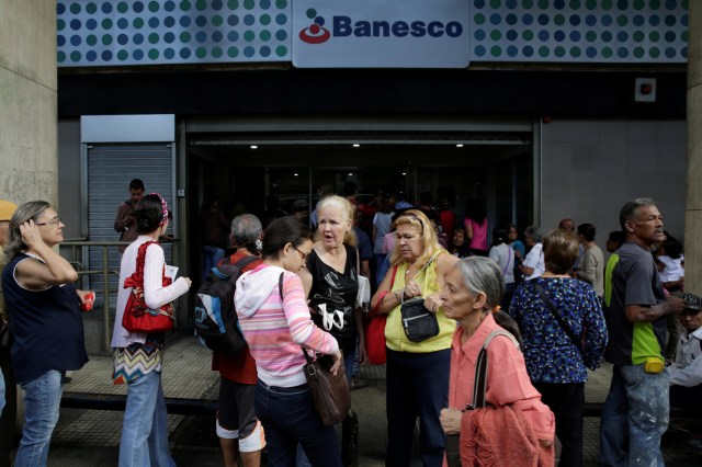 People line up to get into a Banesco bank branch in Caracas, Venezuela December 13, 2016. REUTERS/Marco Bello