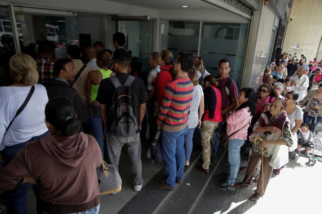People line up to get into a Banesco bank branch in Caracas, Venezuela December 13, 2016. REUTERS/Marco Bello