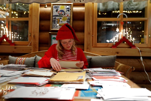 Elina, dressed as a Christmas elf, reads letters from around the world which were sent to Santa Claus at the Santa Claus' Post Office, in the Arctic Circle near Rovaniemi, Finland December 15, 2016. REUTERS/Pawel Kopczynski SEARCH "KOPCZYNSKI SANTA" FOR THIS STORY. SEARCH "THE WIDER IMAGE" FOR ALL STORIES