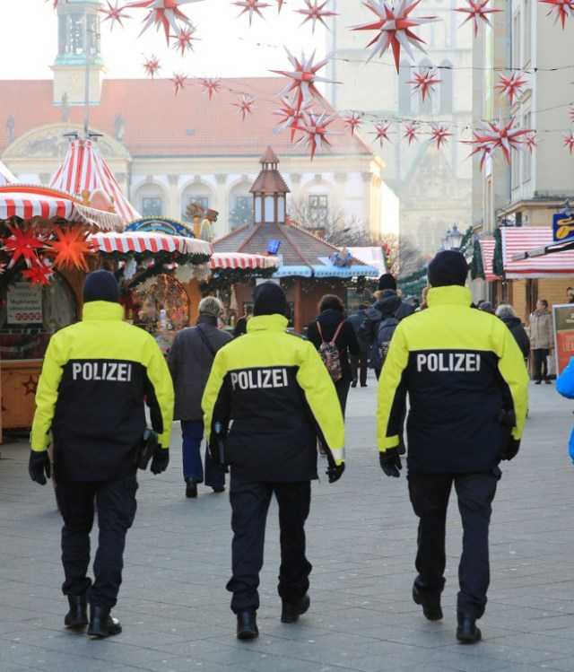 Policemen patrol over a Christmas market in Magdeburg, eastern Germany, on December 20, 2016, as security measures are taken after a deadly rampage by a lorry driver at a Berlin Christmas market. German Chancellor Angela Merkel said that authorities believe the rampage, killing 12, was a "terrorist" attack likely committed by an asylum seeker. / AFP PHOTO / dpa / Peter Gercke / Germany OUT