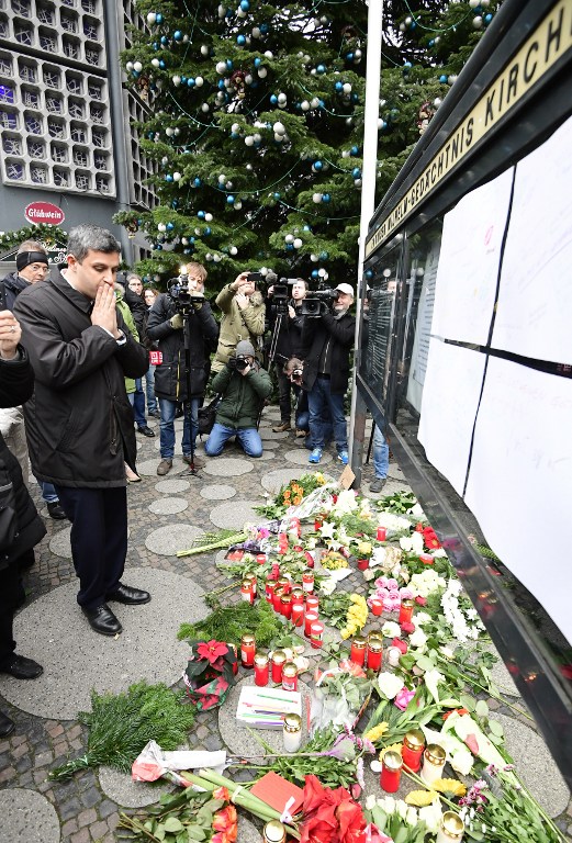 Raed Saleh, Chairman of the SPD (Social Democrats) group in the Berlin's parliament, prays in front at the Kaiser-Wilhelm-Gedaechtniskirche (Kaiser Wilhelm Memorial Church), the day after an attack at the nearby Christmas market in central Berlin, on December 20, 2016. German police said they were treating as "a probable terrorist attack" the killing of 12 people when the speeding lorry cut a bloody swath through the packed Berlin Christmas market. / AFP PHOTO / Tobias SCHWARZ