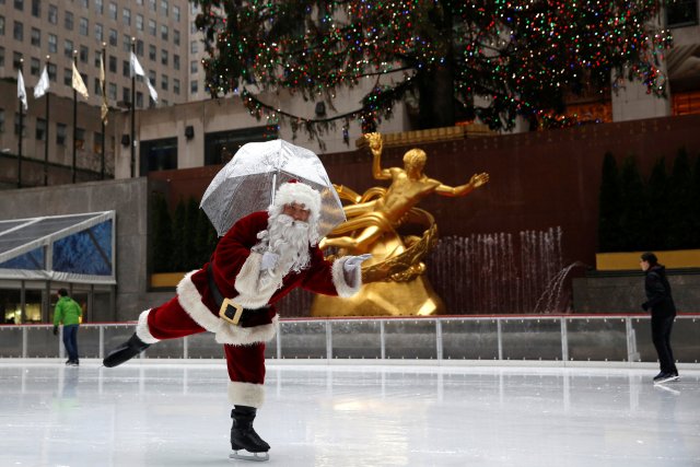 Un hombre vestido como patines de hielo de Papá Noel en la pista en el Rockefeller Center en Nochebuena en Manhattan, Nueva York. REUTERS/Andrew Kelly