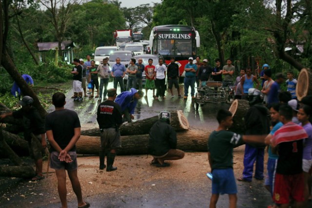 FRM224 PAMPLONA (FILIPINAS) 26/12/2016.- Varios conductores esperan la retirada de un árbol para poder seguir su camino tras el paso del tifón Nock-Ten por la localidad de Pamplona, Camarines Sur (Filipinas), hoy, 26 de diciembre de 2016. Al menos tres personas han muerto en Filipinas durante el paso del tifón Nock-Ten que continúa hoy su avance por el archipiélago con fuertes vientos y copiosas lluvias, informan las autoridades locales. EFE/Francis R. Malasig